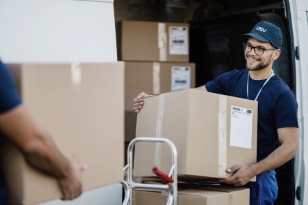 DSV male employee carrying a parcel into a delivery truck