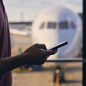 Man in airport using his cell phone